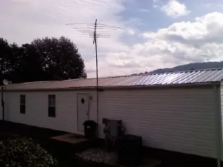 New metal roof on a single wide mobile home with a TV antenna in Houston