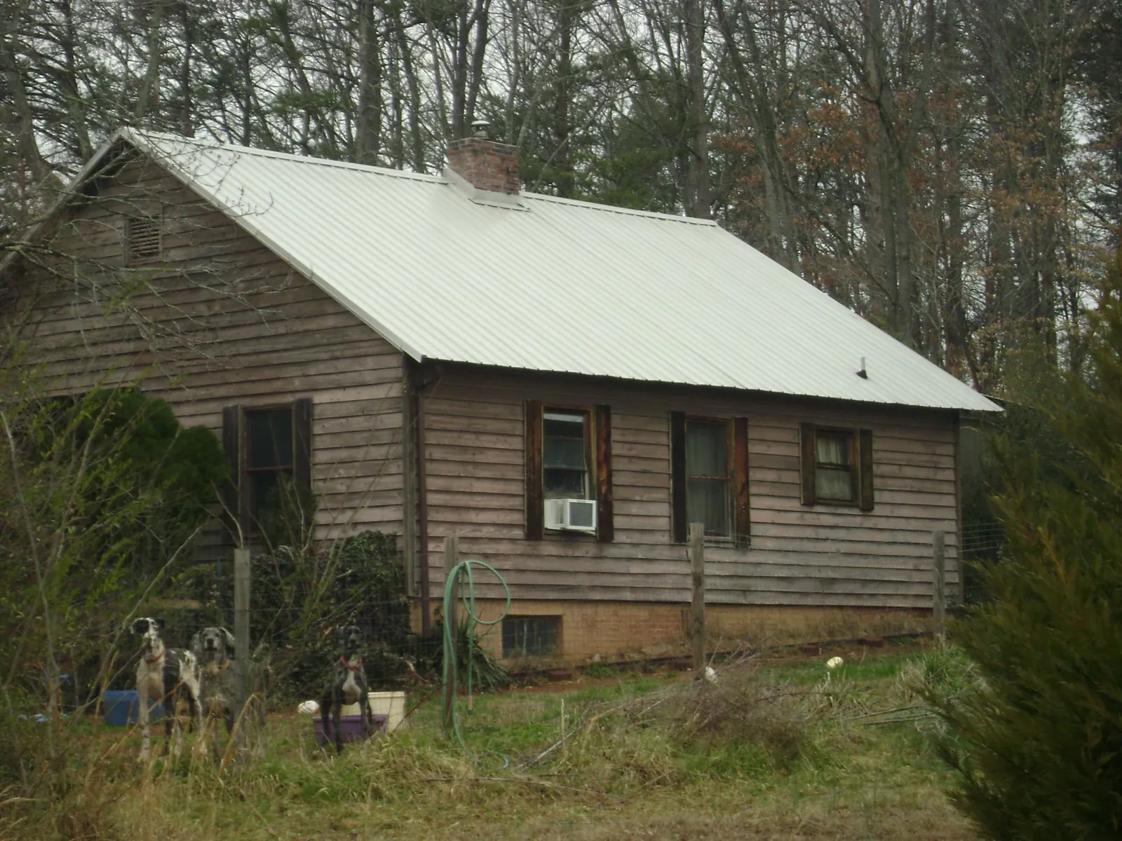 White metal roof on an old wood sided farmhouse, from a Asphalt Shingle Roof Repair job in Houston